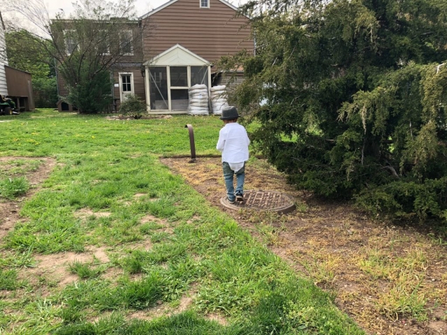Lucien Standing on a Manhole in front of Hunterfly Road Houses